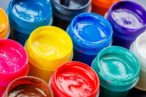 Full-frame close-up background of opened small gouache paint jars Stock Photos