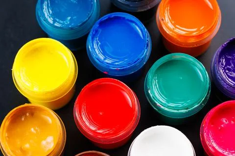 Full-frame close-up background of opened small gouache paint jars Stock Photos