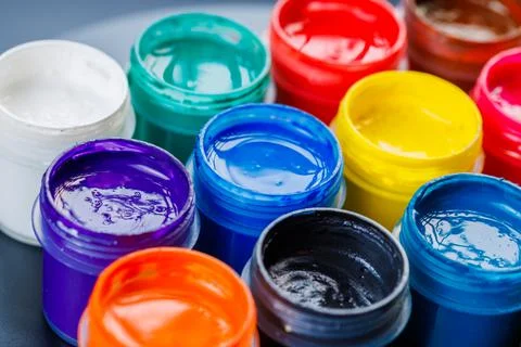Full-frame close-up background of opened small gouache paint jars Stock Photos