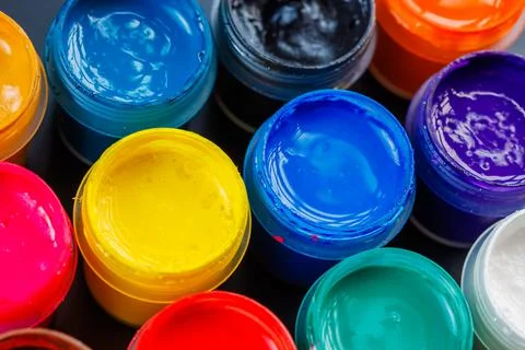 Full-frame close-up background of opened small gouache paint jars Stock Photos