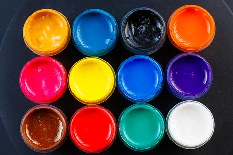 Full-frame close-up background of opened small gouache paint jars Stock Photos