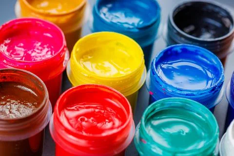 Full-frame close-up background of opened small gouache paint jars Stock Photos