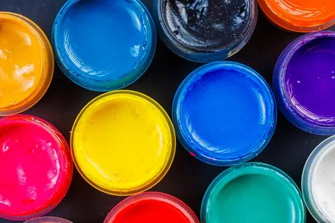 Full-frame close-up background of opened small gouache paint jars Stock Photos