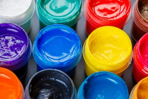Full-frame close-up background of opened small gouache paint jars Stock Photos