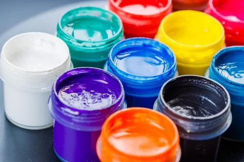 Full-frame close-up background of opened small gouache paint jars Stock Photos