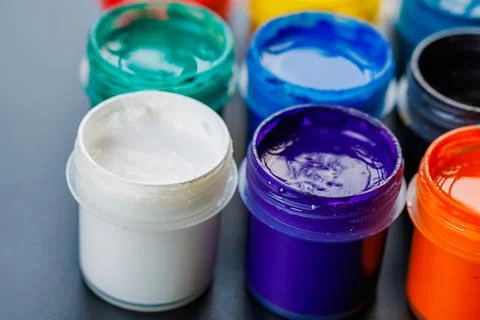Full-frame close-up background of opened small gouache paint jars Stock Photos