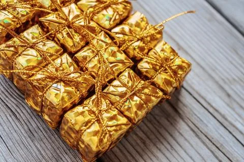 A full-frame close-up of several shiny gold gift boxes tied with gold. Stock Photos