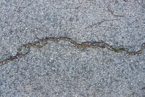 Full frame grunge background of cracked old asphalt pavement Stock Photos