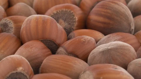 Full frame heap of shelled hazelnuts slowly rotating on the turntable, isolated Stock Footage 96037086
