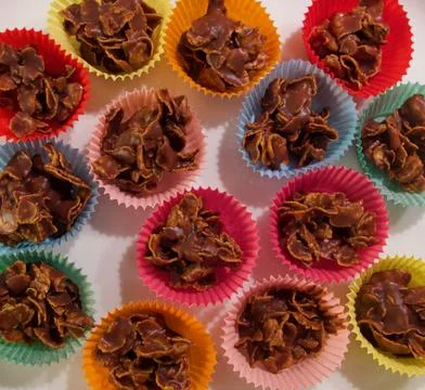 Full frame image of cornflake chocolate crispy cakes in coloured paper cases Stock Photos
