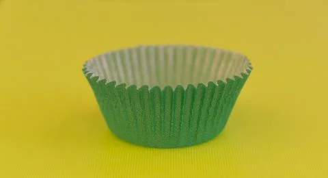 Full frame image of green cup cake paper case on green background Stock Photos