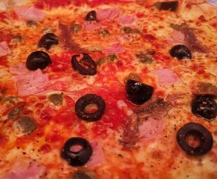 Full frame image of pizza with black olives and tomato Stock Photos