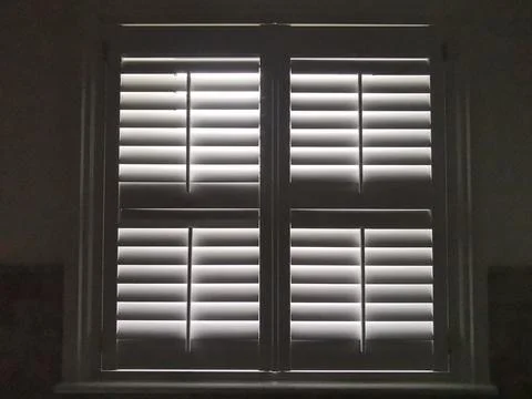 Full frame monochrome image of light shining through plantation shutters Stock Photos