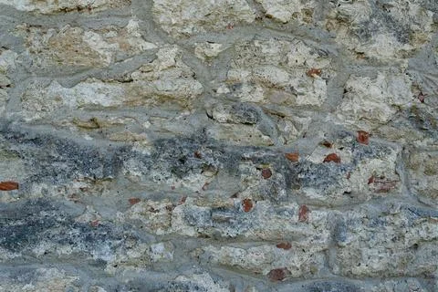 Full frame textured background of ancient weathered stone wall with mortar Stock-Fotos