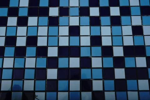 A full-frame top-down abstract background of square ceramic tiles in varying Fotos de archivo