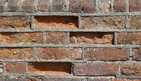 Full frame weathered and worn coarse brick wall background with copy space Stock Photos