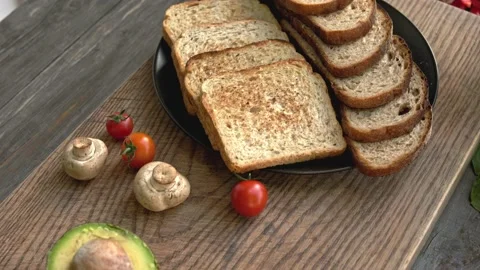 Full grain roasted toast with avocado and green vegetables on the wooden board Stock Footage 160850469