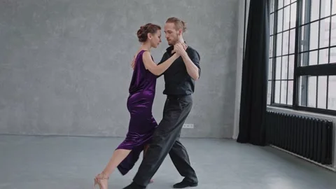 Full growth shot of a pair dancing tango in grey studio with large windows Stock-Footage 168631410
