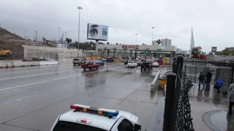 Full HD EXT DAY static Mexico border with car traffic and walking people Stock Footage 72348015