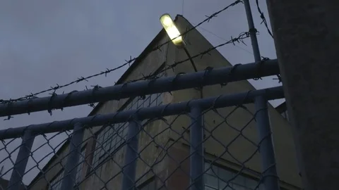 Full HD EXT DUSK static old abandoned building behind a fence  Stock Footage 73110118
