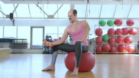 Full height. Bald funny man is training with dumbbells in the gym. Stock Footage 130902124