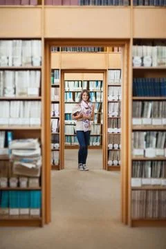 Full lenght of a female student standing in the library Stock Photos