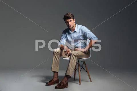 Full length of attractive serious young man in blue shirt Stock Photos