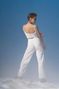 Full length back view of sensual fashion model standing through snow with lig Foto stock