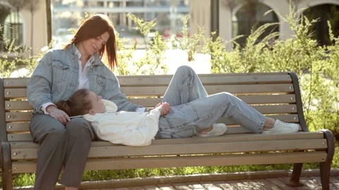 Full length of couple sitting on bench in park and enjoying weekend together Stock Footage 164901476