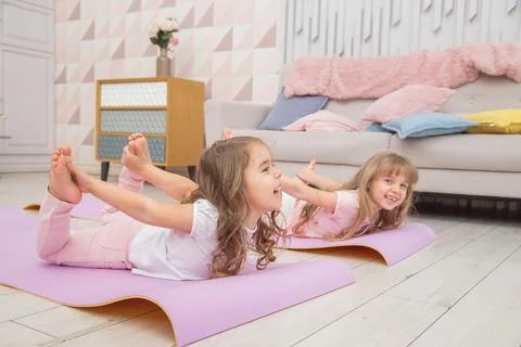 Full length front view smiling cute girls sitting on on yoga mat Stock-Fotos