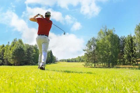 Full length of golf player playing golf on sunny day. Professional male golfe Stock Photos