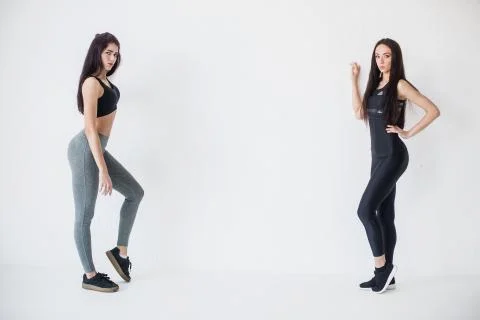 Full-length horizontal shot of two attractive sportive young women in sportwears Stock Photos