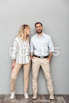 Full length image of happy couple in casual clothing smiling and looking at c Stock Photos