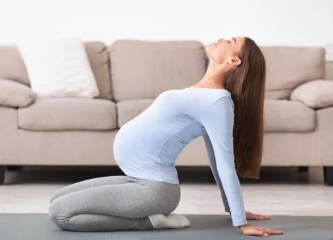 Full length image of pregnant girl doing relaxation exercise Stock Photos