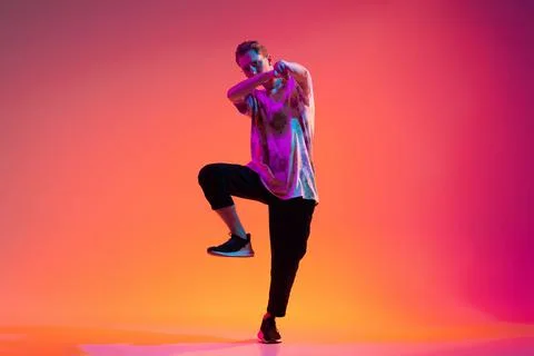 Full-length image of young man dancing hip-hop in trendy clothes isolated over Stock Photos