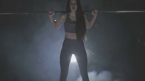 Full length image of a young woman testing her strength by holding a barbell Stock Footage 73107559