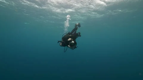 Full length of man spinning while holding camera undersea-Belize City, Belize Stock Footage 149100994
