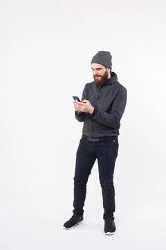 Full length photo of bearded man using smartphone over white background Stock Photos
