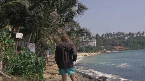 Full length portrait from behind of attractive surfer walking in sand by water Stock Footage 73288032