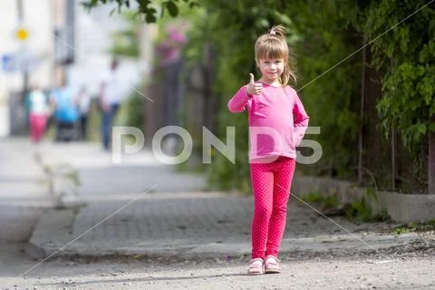 Full length portrait of cute small girl in pink casual clothing and long blon Stock Photos