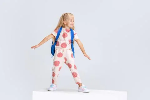 Full-length portrait of little Caucasian preschool girl with backpack posing Stock Photos