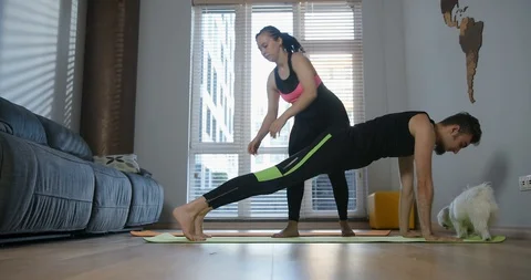 Full length portrait of modern young couple in sportswear doing yoga exercises Stock Footage 113408750