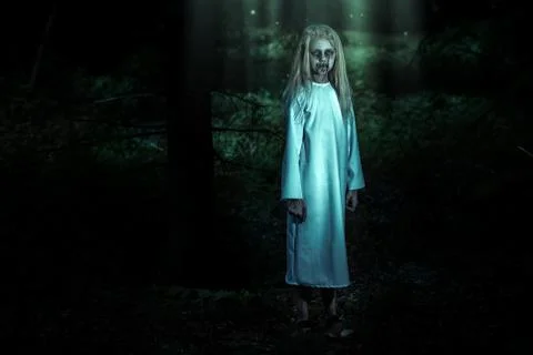 A full length portrait of a scary pale girl from a horror film in the forest. Stock Photos