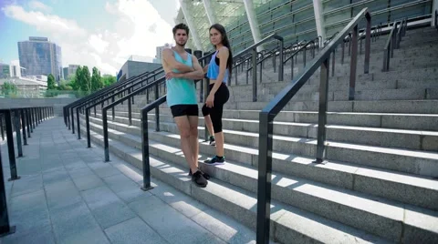 Full-length of satisfied young man and woman after training standing at stairs Stock Footage 65373812