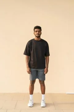 Full length shot of African man wearing oversized black t-shirt Stock Photos