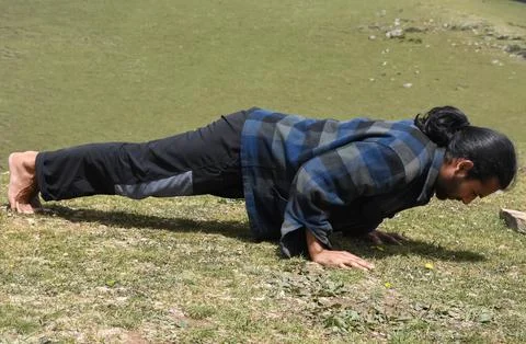 Full length side view of a Indian young man doing push-ups  Stock-Fotos