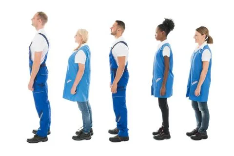 Full length side view of multiethnic janitors standing in queue against white Stock Photos