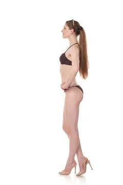 Full length side view slim Caucasian female in bikini looking forward Stock Photos