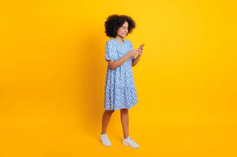 Full-length smiling trendy african american or brazilian curly woman in summer Stock Photos