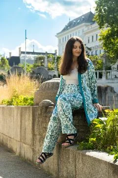 Full length vertical portrait of smiling 38 year old Armenian woman sitting.. Stock Photos